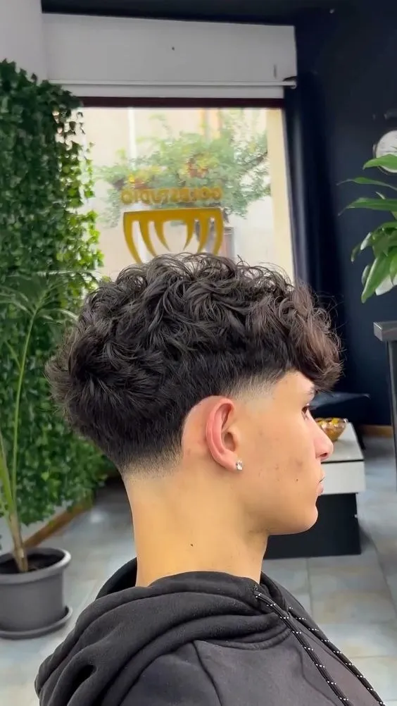 Pria dengan model rambut Curly Taper Fade